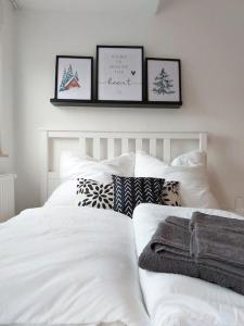 a bedroom with a white bed with three pictures on the wall at Rooftop Apartmens Ulm - komfortable neue Gemeinschaftsunterkunft im Herzen von Ulm - Raum 2 in Ulm