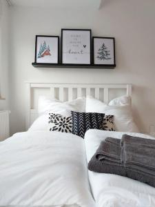 a bedroom with a white bed with three pictures on the wall at Rooftop Apartmens Ulm - komfortable neue Gemeinschaftsunterkunft im Herzen von Ulm - Raum 2 in Ulm +4 photos