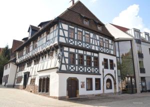 a white and black building on a street at Ferienwohnung Schloßberg Wohnung 2 in Eisenach