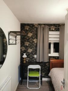 a bedroom with a bed and a green chair at 116 Maison Dieu Road Room E in Dover in Dover