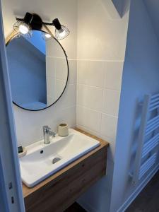 uma casa de banho com um lavatório e um espelho em Appartement T3 cœur de Dinan em Dinan