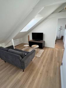uma sala de estar com um sofá e uma televisão em Appartement T3 cœur de Dinan em Dinan