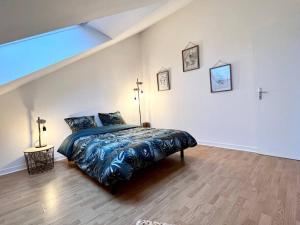 um quarto com uma cama grande num quarto branco em Appartement T3 cœur de Dinan em Dinan