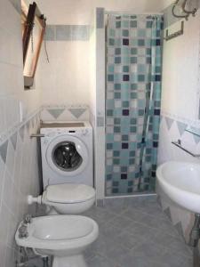 La petite salle de bains est pourvue de toilettes et d'un lavabo. dans l'établissement Villetta Trilocale con Giardino 1.3, à Porto Pollo