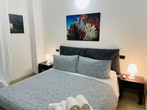 a bedroom with a blue bed with two lamps at Regina Del Mare Holiday Apartments in Tirrenia