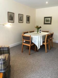 a dining room with a table and some chairs at Glenheurie Cottage in Polmood