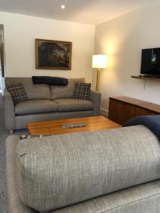 a living room with a couch and a coffee table at Glenheurie Cottage in Polmood
