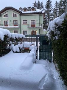 a house with a fence covered in snow at Casa Felicia in Pescasseroli