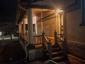 a porch of a house with a staircase at night at Downen House Bed & Breakfast in Pueblo