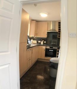 a kitchen with wooden cabinets and a stove top oven at Lategillan Cottage in Polmood