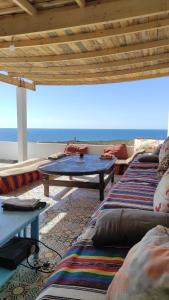 - un salon avec une table et une vue sur l'océan dans l'établissement EL Faro Surfstay, à Tamri 37 autres photos
