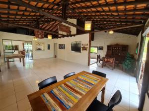 uma sala de jantar com uma mesa de madeira e cadeiras em Condomínio Paraíso do Rosa em Imbituba