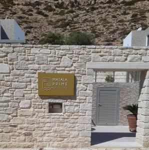 a stone wall with a sign for a building at Matala Prime Villas in Matala