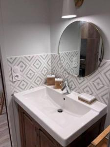 a bathroom with a white sink and a mirror at Proche gare, cosy, courte et moyenne durée in Bellegarde-sur-Valserine