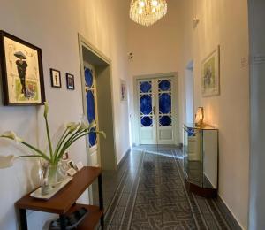 un pasillo con una puerta, una mesa y una planta en Le Muse, en Pisa