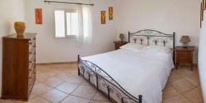 1 dormitorio con 1 cama grande y vestidor de madera en Pajara Chicca, en Morciano di Leuca