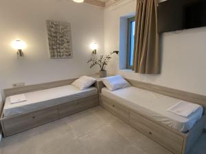 two beds in a room with a window at Matala Prime Villas in Matala