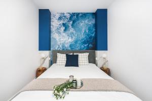 a bedroom with a bed with a painting on the wall at Pearl Apartment by LoftAffair in Gdańsk