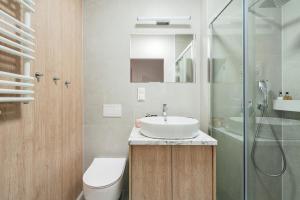 uma casa de banho com um lavatório, um WC e um chuveiro em Pearl Apartment by LoftAffair em Gdansk