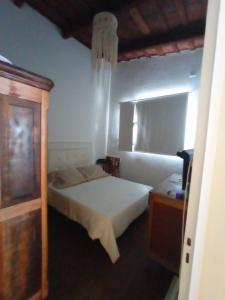 1 dormitorio con cama blanca y armario de madera en Mari mari en Gualeguaychú