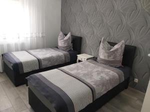 two twin beds in a room with a wall at EBS Paradies in Rheinhausen