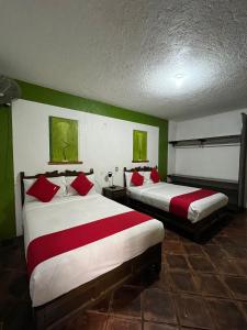 2 Betten in einem Zimmer mit Grün und Weiß in der Unterkunft GRUPO MARMIL 