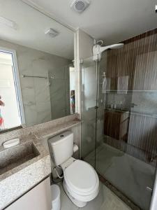a bathroom with a toilet and a glass shower at Flat à Beira Mar Com Varanda e Piscinas Naturais in Ipojuca