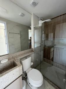 a bathroom with a toilet and a glass shower at Flat à Beira Mar Com Varanda e Piscinas Naturais in Ipojuca