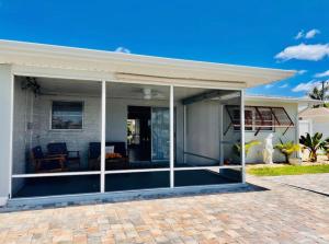 Ein Haus mit einer abgeschirmten Veranda mit einem Dach in der Unterkunft Cheerful home with two Bedrooms in Cape Coral