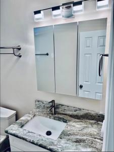 W łazience znajduje się umywalka i lustro. w obiekcie Cheerful home with two Bedrooms w mieście Cape Coral