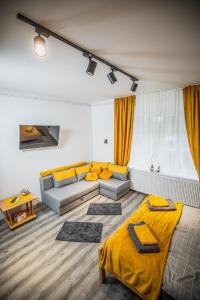 ein Wohnzimmer mit 2 Betten und einem Sofa in der Unterkunft Cent-room apartman Ada in Ada