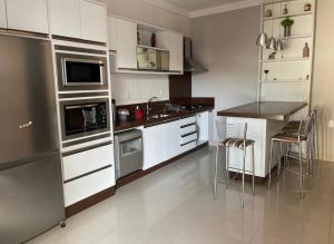 a kitchen with white cabinets and a black counter top at Casa no centro de Balneário Camboriú in Balneário Camboriú