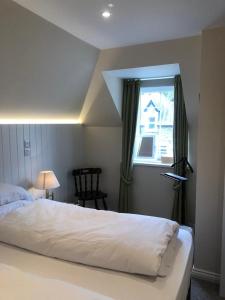 a bedroom with a white bed and a window at Manyleith Rig Cottage in Polmood