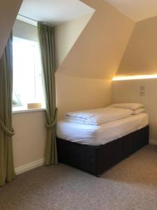 a bed sitting in a room with a window at Manyleith Rig Cottage in Polmood