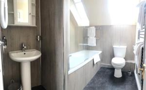 y baño con lavabo, aseo y bañera. en Manyleith Rig Cottage en Polmood