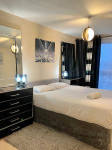 a bedroom with two beds and a large mirror at Radiant2 bedroom apartment in the heart of Harlow town in Harlow