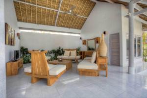 una sala de estar con sofás, mesas y sillas en Villa Noa by Optimum Bali Villas, en Seminyak
