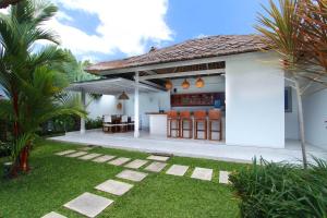 a white house with a bar in the backyard at Villa Noa by Optimum Bali Villas in Seminyak