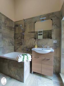 a bathroom with a tub and a sink and a mirror at Casa Vacanze Donna Erminia in Calitri