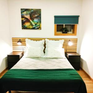 una camera da letto con un grande letto con due comodini di Herama Garden Guesthouse a Vila Nova de Gaia