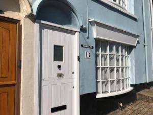 a blue building with a white door and a window at Mariners, Fisherman's Cottage in the Heart of the Harbour with Wonderful Sea Views & Free Dedicated Parking in Brixham
