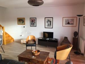 uma sala de estar com mesa e cadeiras em Appartement Le Golf em Wimereux