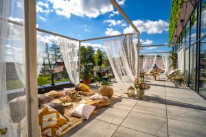 patio z łóżkiem i zasłonami na balkonie w obiekcie Mazurski Raj - Hotel, Marina & Spa w mieście Ruciane-Nida