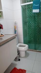 a bathroom with a toilet and a green shower at Beach Class Eco Life in Porto De Galinhas