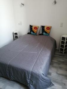 1 dormitorio con 1 cama y 2 almohadas en 2 appartements au choix centre ville de Souillac entre Sarlat et Rocamadour, en Souillac