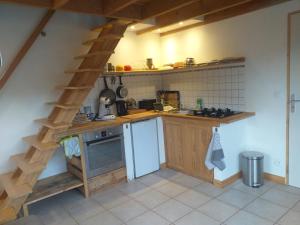 cocina con escalera de madera en una habitación en Mon chalet au cœur des Cévennes, en Vébron
