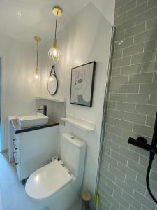 Baño blanco con aseo y lavamanos en Appartement standing 2 pièces tout équipé avec jardin et parking privé, 