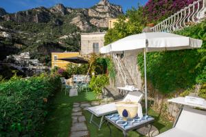 a patio with a table and an umbrella at Villa Dalu in Positano