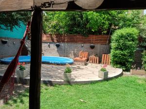 een achtertuin met een zwembad en een tafel en stoelen bij Merlo Hostel in Merlo