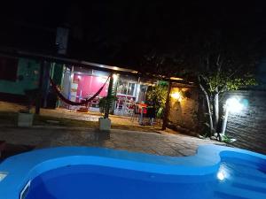 een zwembad voor een huis 's nachts bij Merlo Hostel in Merlo